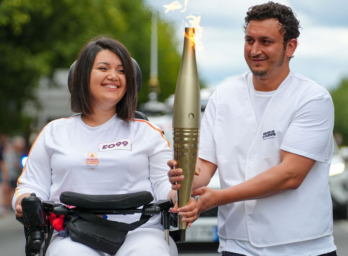 Photo de Rajae, l'une de nos bénéficiaires atteinte de Myopathie, portant la flamme olympique.
